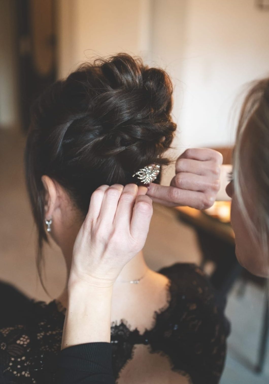 Eine Brautfrisur Nahaufnahme einer eleganten, gesteckten Brautfrisur mit floralem Haarschmuck, gestylt am von mobiler Stylistin Veronika Raimkulow